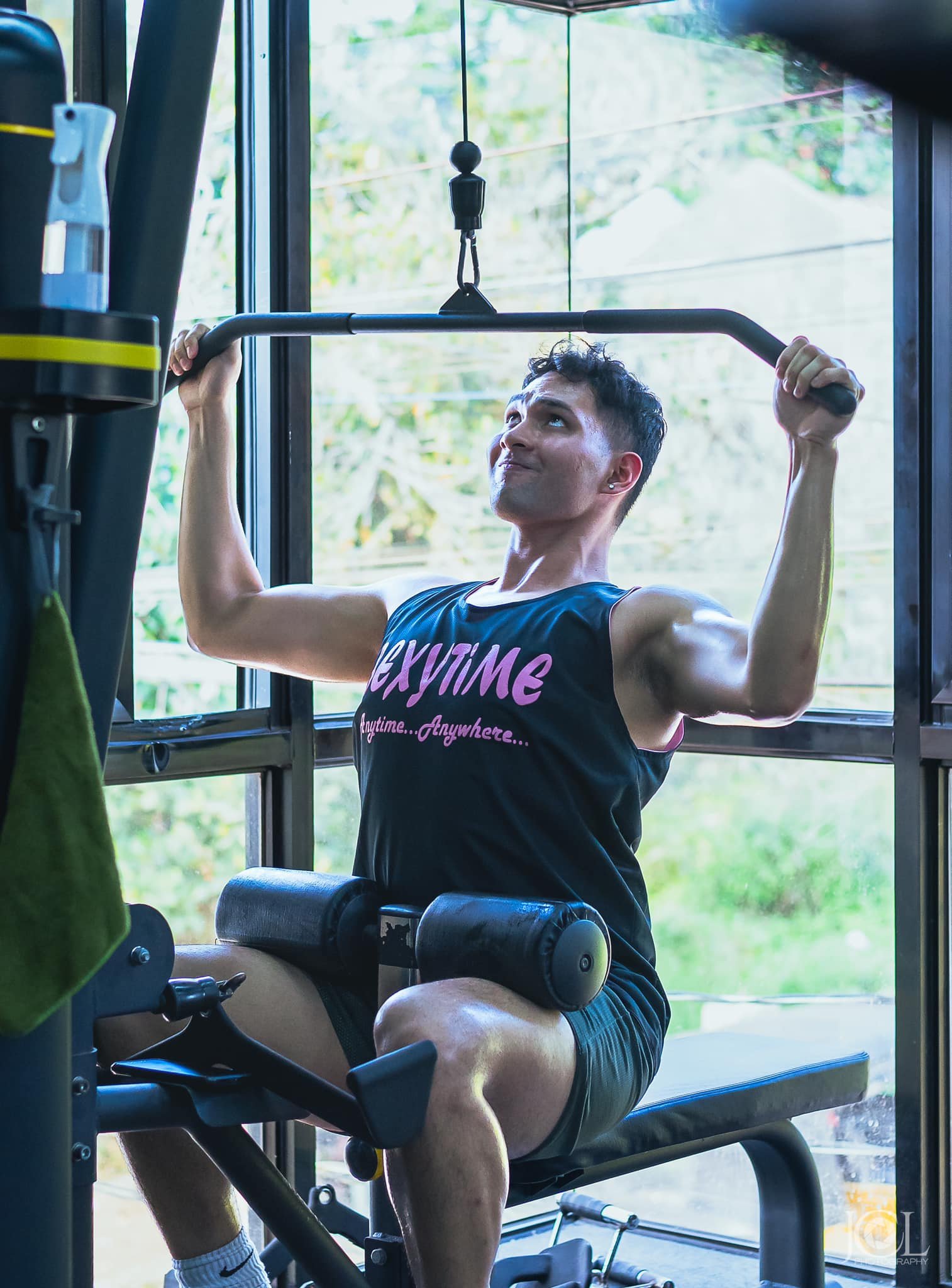 Man performing a pulldown exercise in a gym, demonstrating strength training benefits of regular gym workouts.